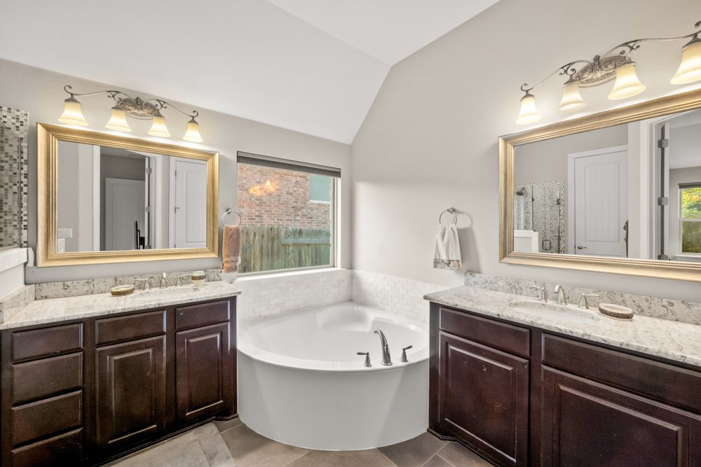 1589 Cool Spring Way Austin, TX 78737 - Photo 15 of 32 The primary bath features separate vanities and a large soaking tub plus a separate shower.