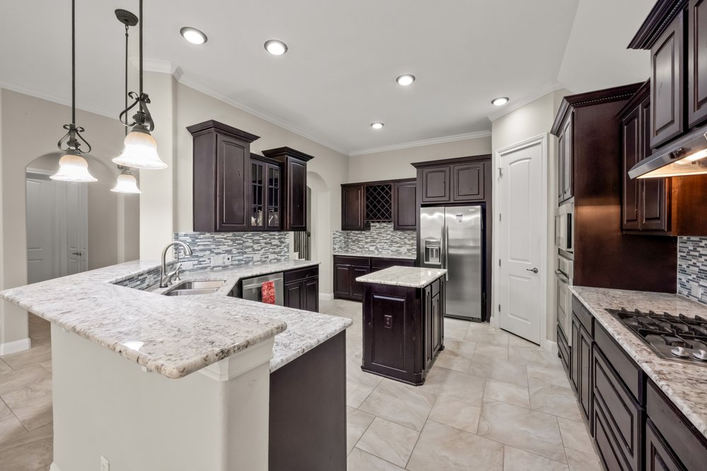 1589 Cool Spring Way Austin, TX 78737 - Photo 6 of 32 Open kitchen with stainless appliances, including a gas cooktop.