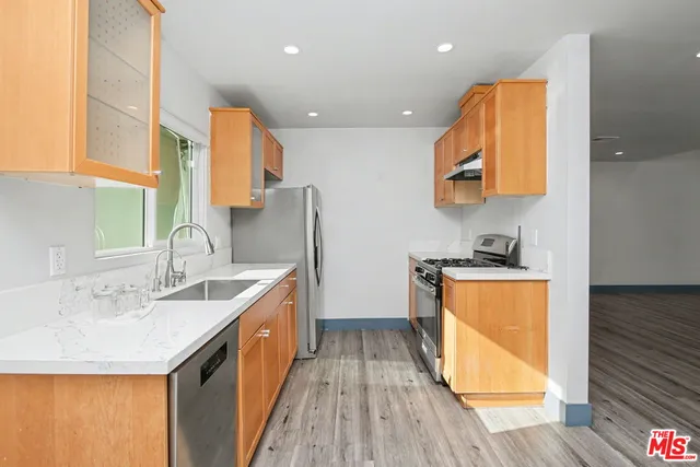 a kitchen with stainless steel appliances granite countertop a sink and a stove