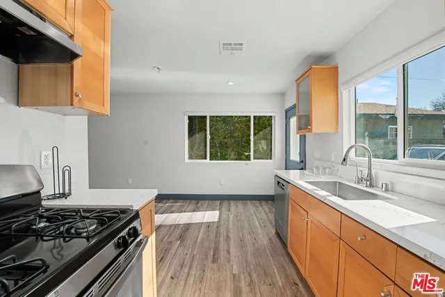 a kitchen with a sink a stove and a window