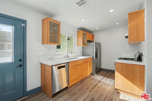 a kitchen with stainless steel appliances granite countertop a sink stove and refrigerator