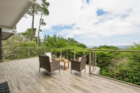 a view of a roof deck with furniture
