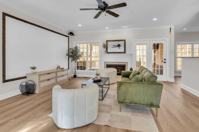 a living room with furniture a fireplace and a ceiling fan