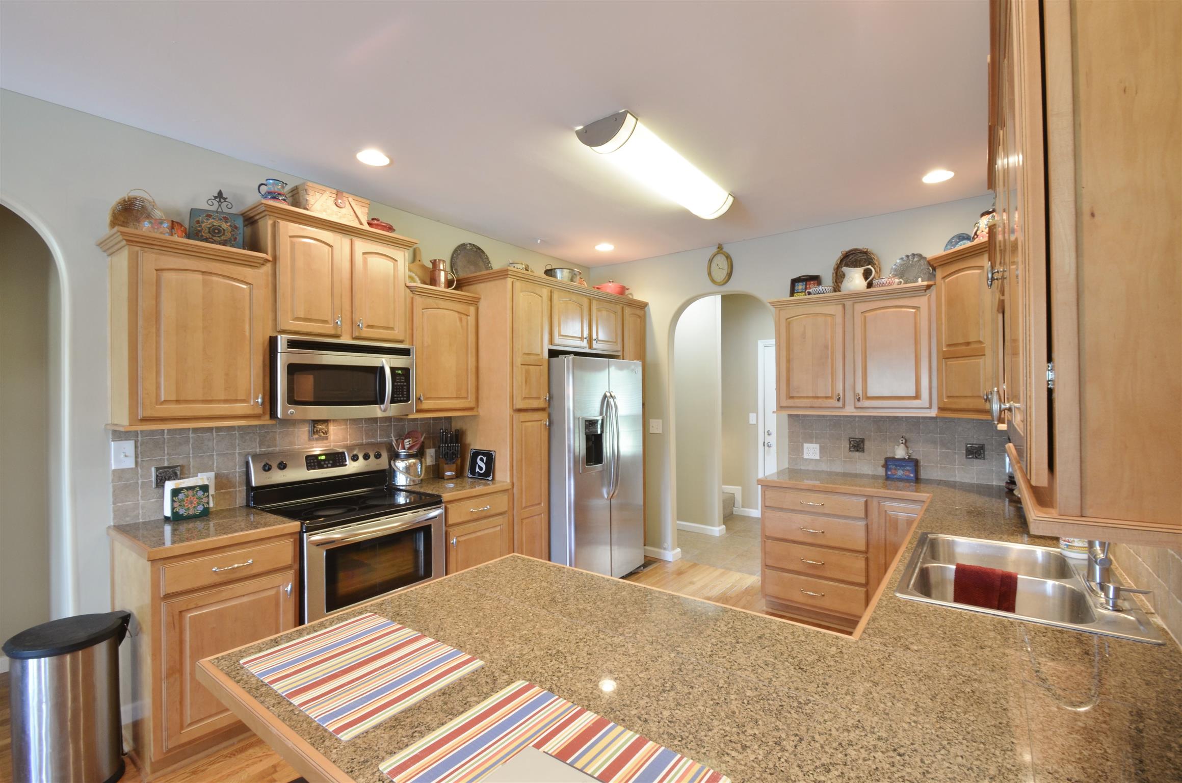 391 Vesta Road Lebanon, TN 37090 - Photo 6 of 24 a kitchen with stainless steel appliances kitchen island granite countertop a sink refrigerator and cabinets