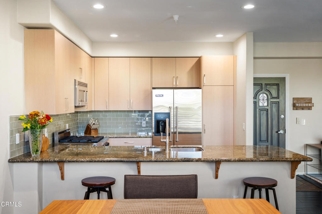 436 Poli Street, Unit 404 Ventura, CA 93001 - Photo 12 of 32 a kitchen with granite countertop a sink and a refrigerator