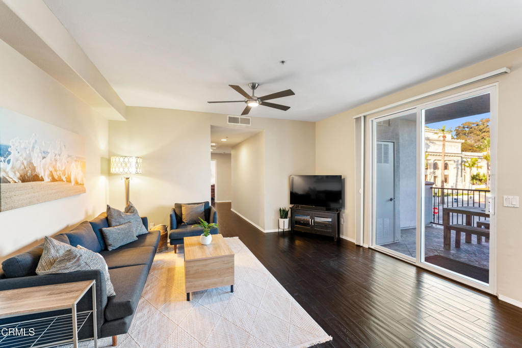 436 Poli Street, Unit 404 Ventura, CA 93001 - Photo 16 of 32 a living room with furniture a wooden floor and a chandelier