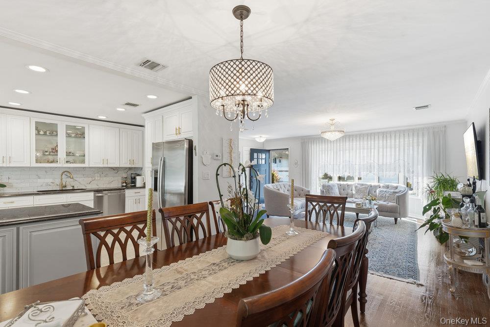 20 Vista Road Plainview, NY 11803 - Photo 11 of 37 a view of a dining room and livingroom with furniture wooden floor a chandelier