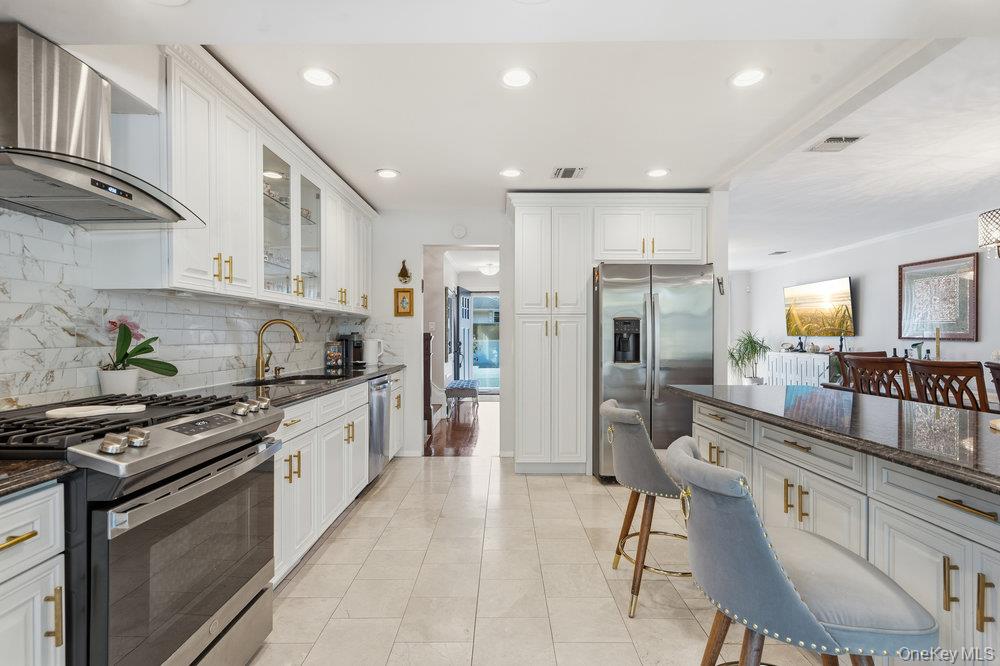 20 Vista Road Plainview, NY 11803 - Photo 14 of 37 a large kitchen with stainless steel appliances granite countertop a stove a sink a refrigerator and a wooden cabinets