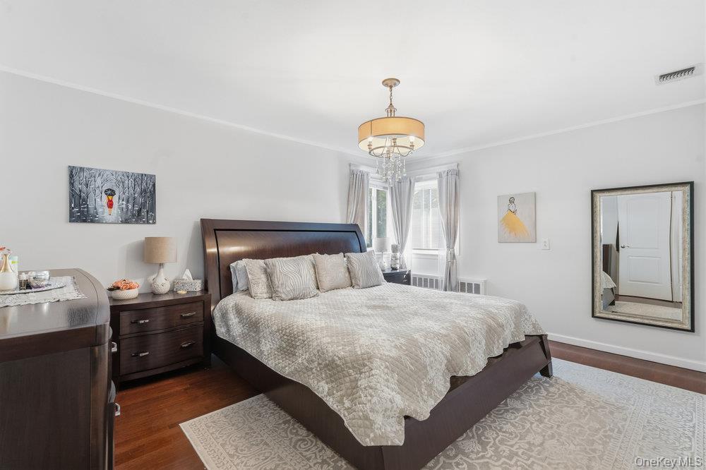 20 Vista Road Plainview, NY 11803 - Photo 29 of 37 a bedroom with a bed and a chandelier