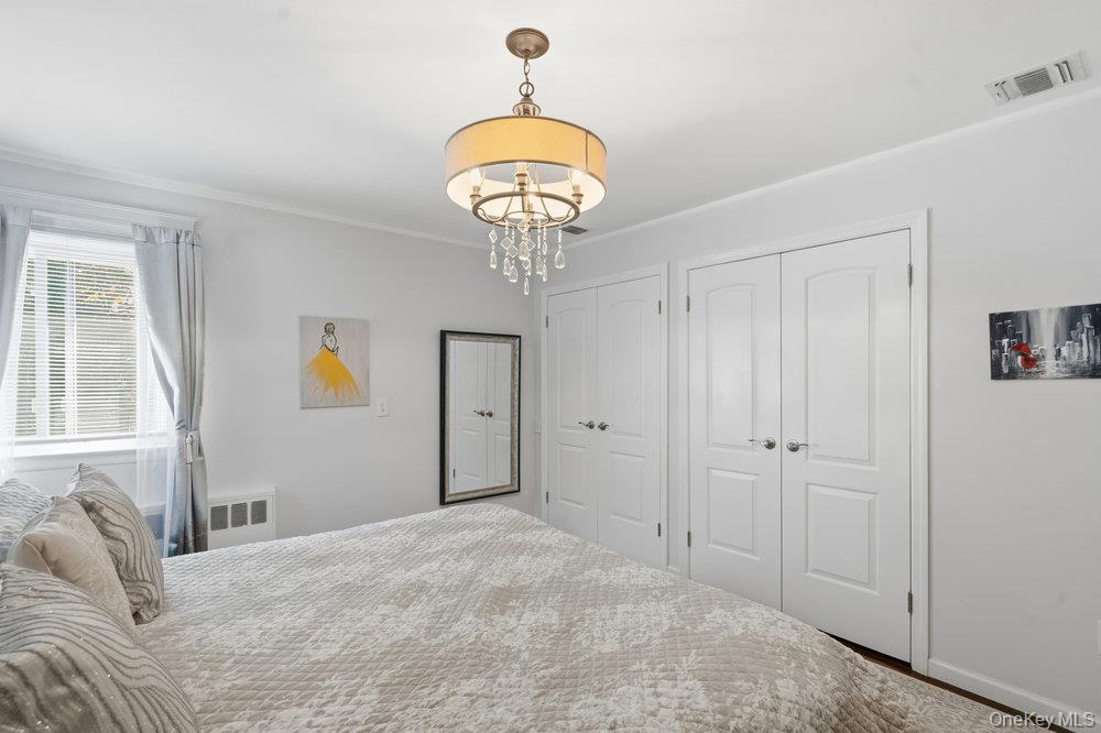 20 Vista Road Plainview, NY 11803 - Photo 30 of 37 a bedroom with a bed and a chandelier