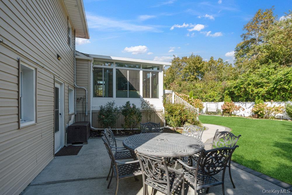 20 Vista Road Plainview, NY 11803 - Photo 37 of 37 a view of a patio with table and chairs and potted plants with wooden fence