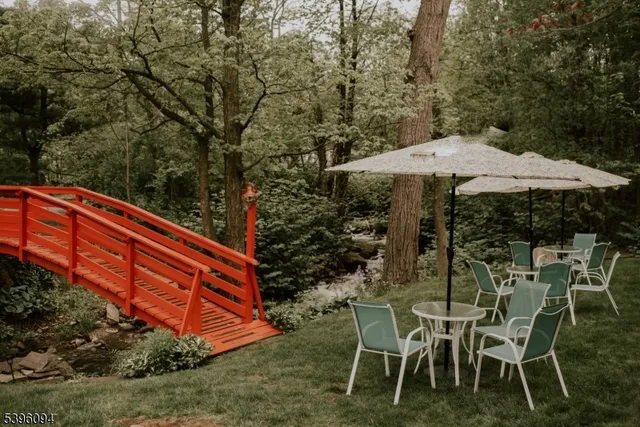 a backyard of a house with table and chairs under an umbrella