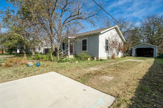 a view of a house with backyard and trees