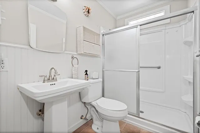 a bathroom with a sink a toilet and shower