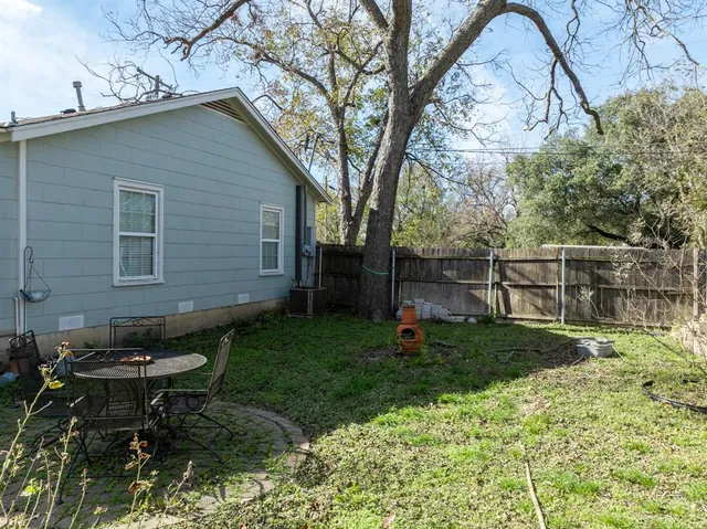 a backyard of a house with table and chairs