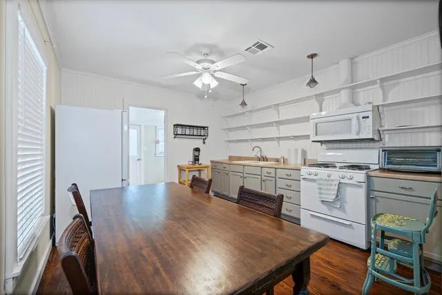a kitchen with a table chairs refrigerator and cabinets