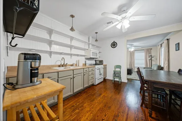 a kitchen with stainless steel appliances granite countertop a stove a sink dishwasher and a refrigerator with wooden floor