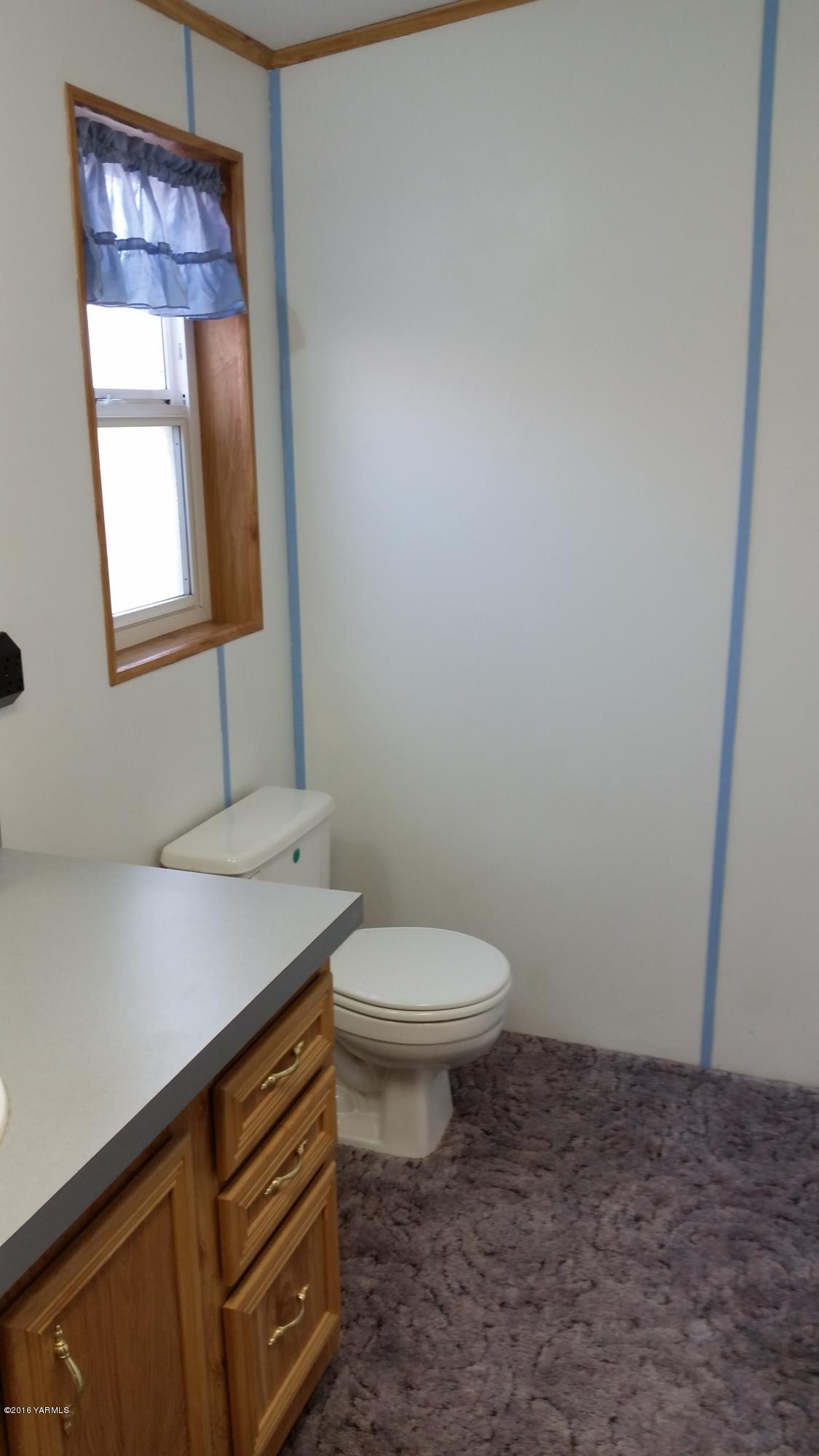 2211 Rosenkranz Road Tieton, WA 98947 - Photo 14 of 29 a bathroom with a toilet sink and mirror