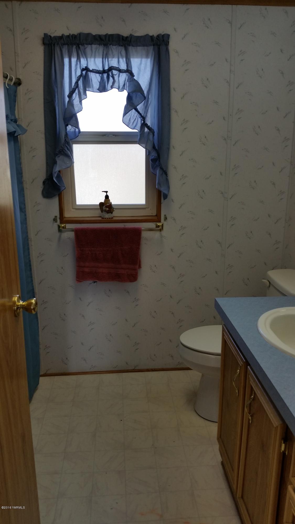 2211 Rosenkranz Road Tieton, WA 98947 - Photo 22 of 29 a bathroom with a toilet a sink and mirror