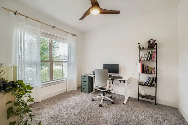 a view of a workspace with furniture and a window