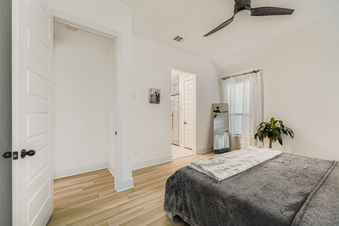 324 Clear Frk Loop Liberty Hill, TX 78642 - Photo 16 of 28 a spacious bedroom with a bed and a chandelier