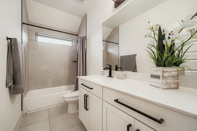 a bathroom with a granite countertop sink a toilet and shower