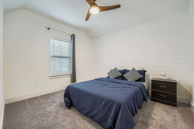 a bed sitting in a bedroom next to a window