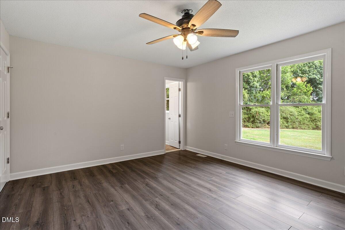 805 Rand Road Garner, NC 27529 - Photo 30 of 38 a view of an empty room with a window and wooden floor