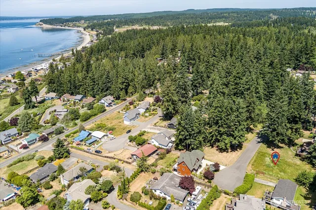 an aerial view of residential houses with outdoor space and trees