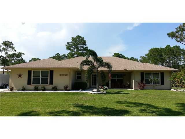 12757 Sandy Run Road Jupiter, FL 33478 - Photo 1 of 25 a front view of a house with a yard