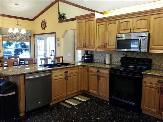 12757 Sandy Run Road Jupiter, FL 33478 - Photo 3 of 25 a kitchen with stainless steel appliances granite countertop a stove a sink and a microwave