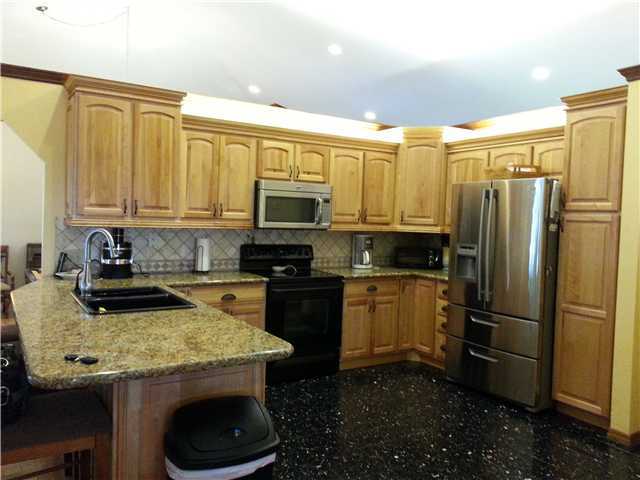 12757 Sandy Run Road Jupiter, FL 33478 - Photo 5 of 25 a kitchen with a sink a microwave a refrigerator and cabinets