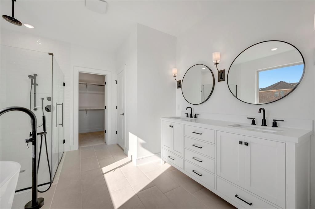 1014 Butterfly Lane Justin, TX 76247 - Photo 14 of 40 a spacious bathroom with a double vanity sink double mirror and a shower