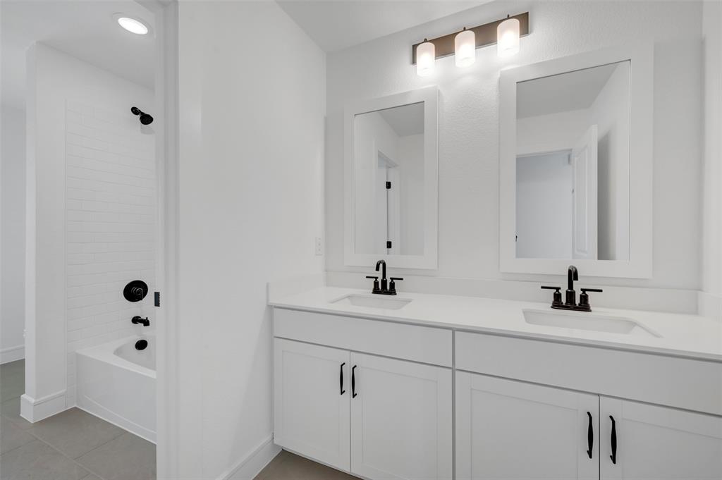 1014 Butterfly Lane Justin, TX 76247 - Photo 25 of 40 a bathroom with a sink and a mirror