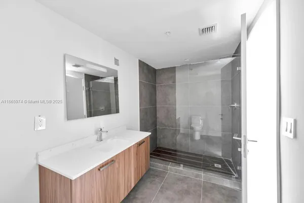 a bathroom with a double vanity sink mirror double and shower