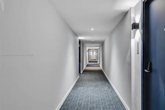 a spacious bedroom with a large window and a chandelier