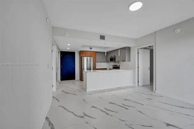 a view of kitchen with refrigerator and window