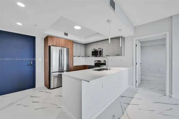 a kitchen with stainless steel appliances a refrigerator sink and stove