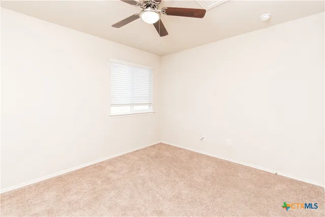 an empty room with a chandelier fan
