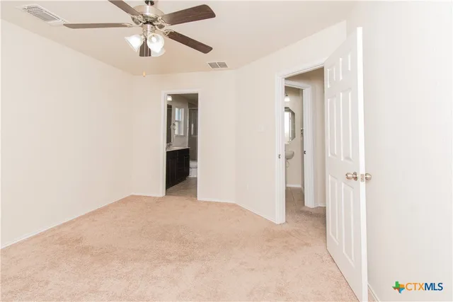 a view of an empty room with a chandelier fan