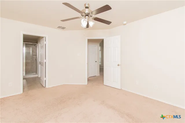 an empty room with a ceiling fan and a window