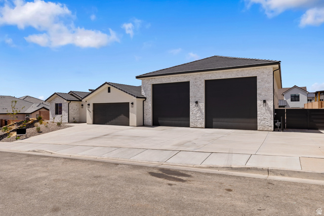 2955 East Rimrunner Drive St. George, UT 84790 - Photo 34 of 35 Modern stucco exterior with dark trim accents and a black shingle roof