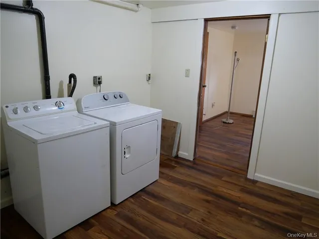 a utility room with wooden floor washer and dryer