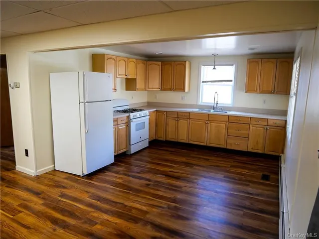 a large kitchen with wooden floors and stainless steel appliances