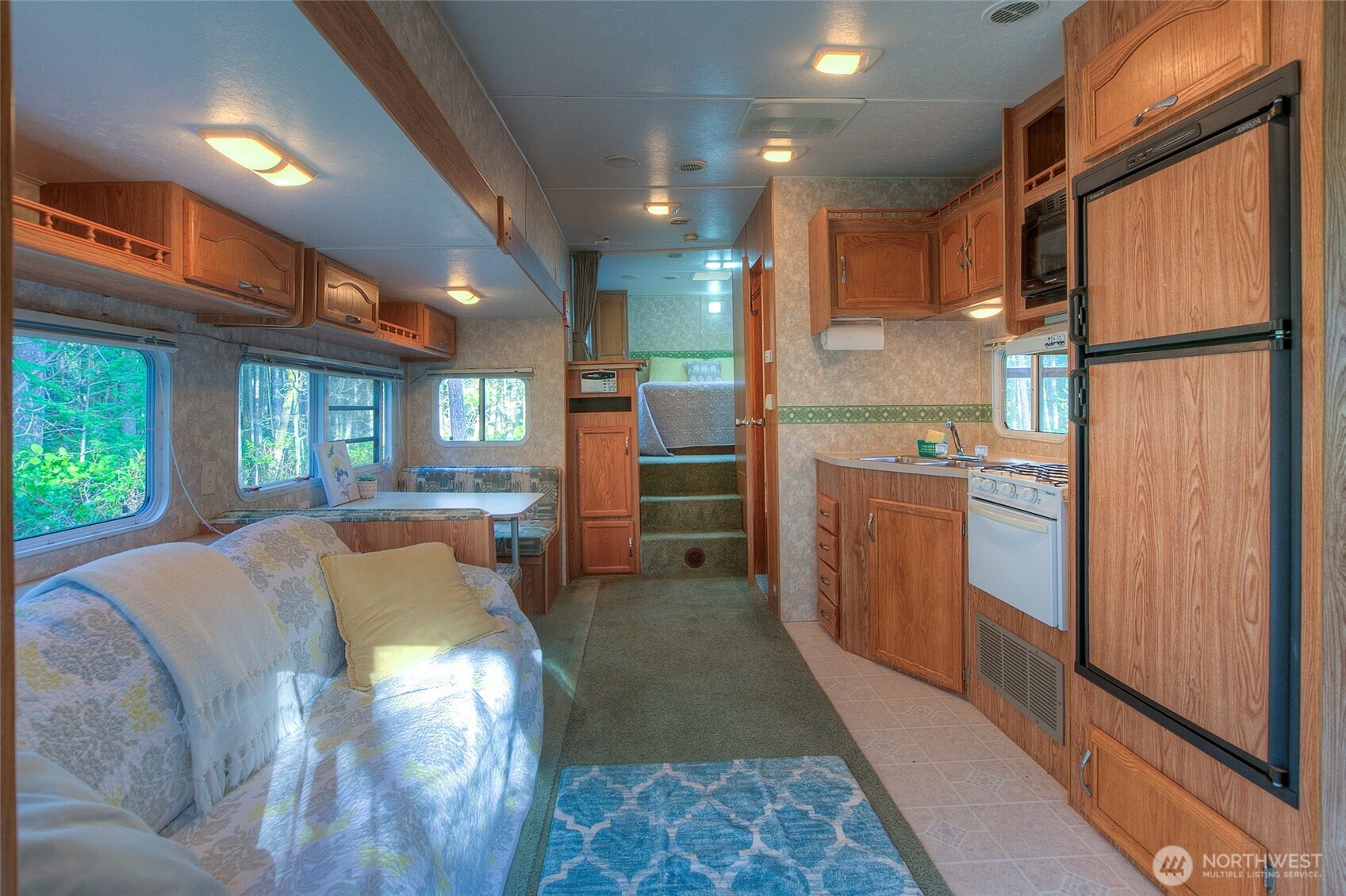 67 Frances Lane Lopez Island, WA 98261 - Photo 11 of 32 a kitchen with stainless steel appliances granite countertop a refrigerator a sink dishwasher and a fireplace with wooden floor