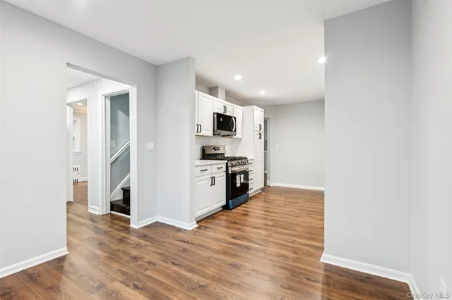 a kitchen with granite countertop a refrigerator and a stove top oven