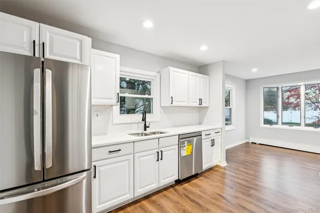 a kitchen with a sink stainless steel appliances and window