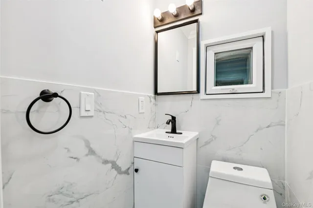 a bathroom with a sink a toilet and a mirror