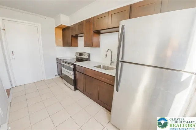 a kitchen with stainless steel appliances a sink stove and cabinets