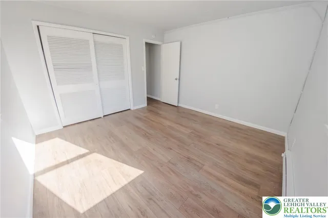 a view of an empty room with wooden floor